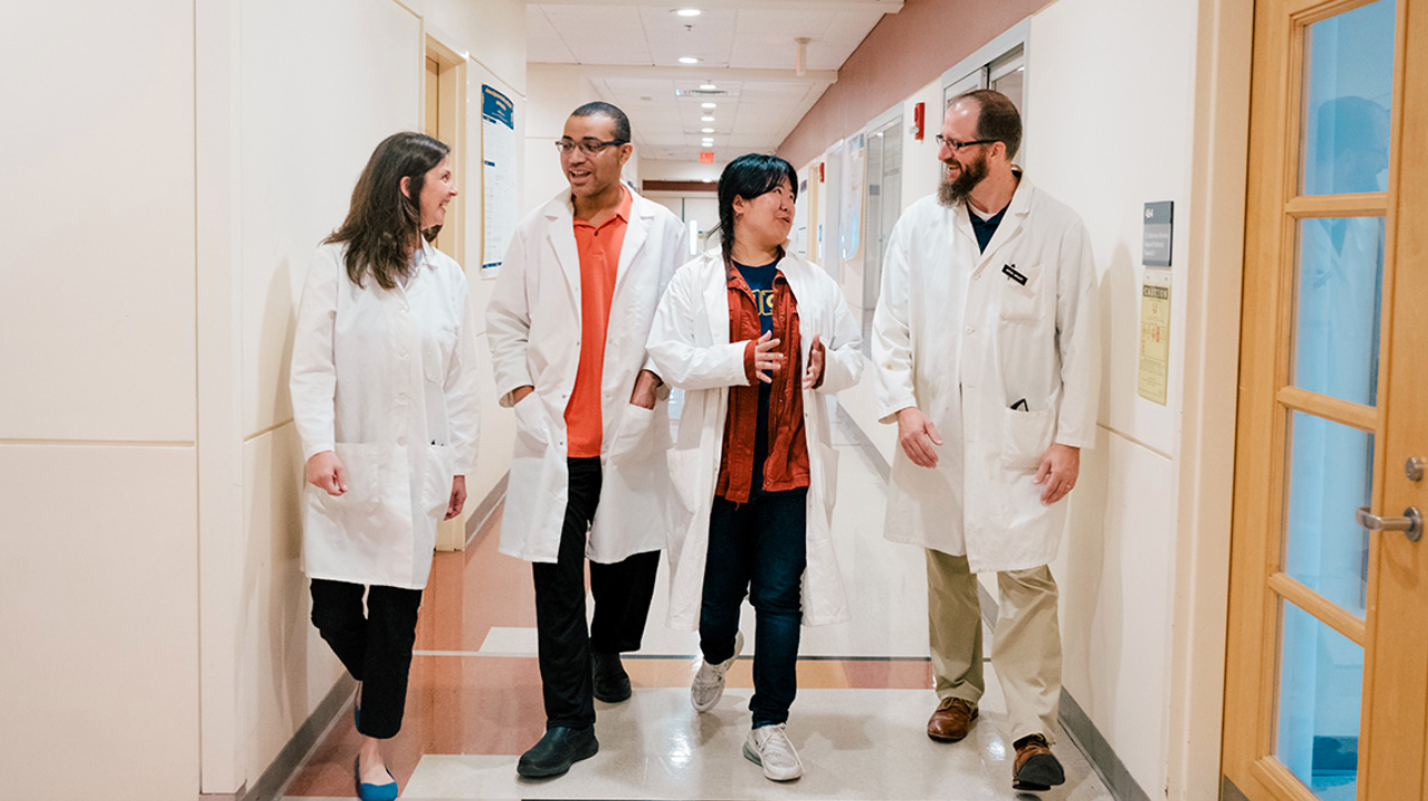 Researchers walking through UNCG's science building